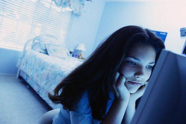Teenager Using Computer in Bedroom --- Image by   L. Clarke/CORBIS