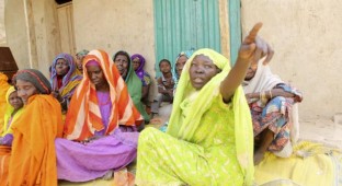 Women who survived Boko Haram occupation sit on the ground in Damasak