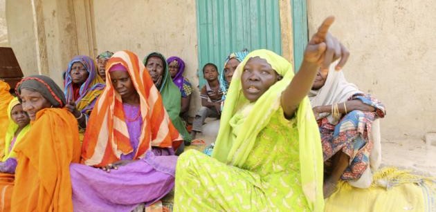 Women who survived Boko Haram occupation sit on the ground in Damasak