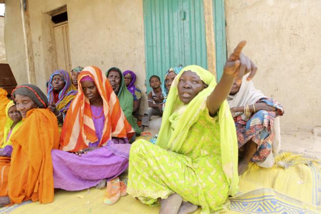Women who survived Boko Haram occupation sit on the ground in Damasak