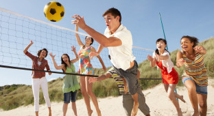 Group Of Teenage Friends Playing Volleyball On Beach