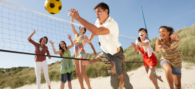 Group Of Teenage Friends Playing Volleyball On Beach