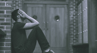 Stressed out student in hallway of school building.