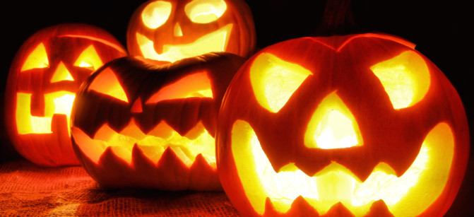 Group of spooky Halloween Jack o Lanterns lit at night