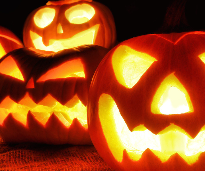 Group of spooky Halloween Jack o Lanterns lit at night