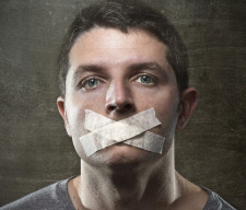 attractive young man with mouth sealed on duct tape to prevent him from speaking