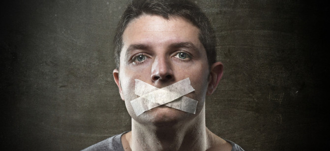 attractive young man with mouth sealed on duct tape to prevent him from speaking