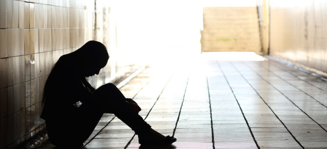 Teenager depressed sitting inside a dirty tunnel