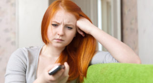 Red-haired  teenager girl  having disappointment  after phone call