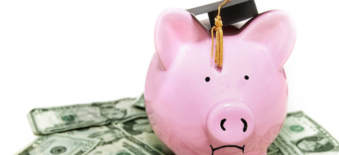 frowning piggy bank with graduation cap, on cash