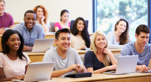 Students Using Laptops And Digital Tablets In Lecture