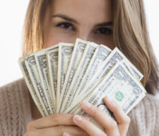 Woman peeking behind money