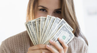 Woman peeking behind money