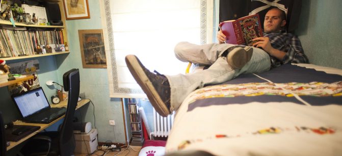 Pablo Vega, a former video-game tester for Electronic Arts Inc. who is forced to live at home because of his job situation, reads a book in his bedroom in Madrid, Spain, on Monday, May 28, 2012. More than half of all workers under age 24 are jobless and 37 percent of Spaniards between 18 and 34 live with their parents. Photographer: Angel Navarrete/Bloomberg *** Local Caption *** Pablo Vega Gonzalez