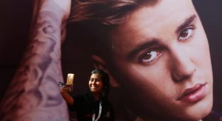 A girl takes a selfie in front of a hoarding outside the venue of Canadian singer Justin Bieber concert in Mumbai, India May 10, 2017. REUTERS/Shailesh Andrade