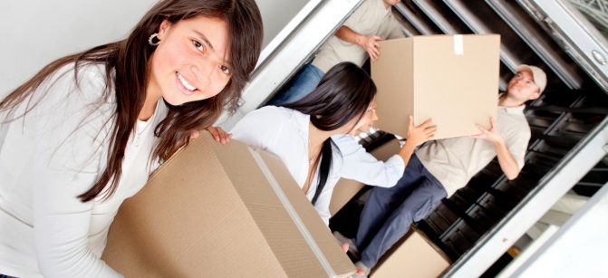 Girls moving house and unloading boxes from a truck