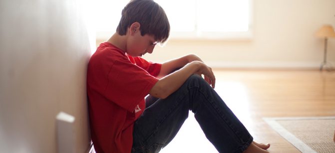 Boy sitting against wall