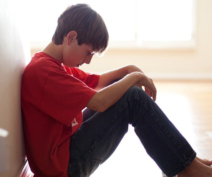 Boy sitting against wall