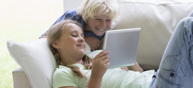 Smiling brother and sister ipad girl Middle