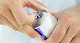 Close-up of a man's hands opening a soft drink can