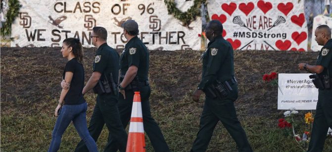 Marjory Stoneman Douglas High School staff, teachers and students return to school greeted by police and well wishers in Parkland, Florida on February 28, 2018. 
Students grieving for slain classmates prepared for an emotional return Wednesday to their Florida high school, where a mass shooting shocked the nation and led teen survivors to spur a growing movement to tighten America's gun laws. The community of Parkland, Florida, where residents were plunged into tragedy two weeks ago, steeled itself for the resumption of classes at Marjory Stoneman Douglas High School, where nearby flower-draped memorials and 17 white crosses pay tribute to the 14 students and three staff members who were murdered by a former student.
 / AFP PHOTO / RHONA WISE        (Photo credit should read RHONA WISE/AFP/Getty Images)