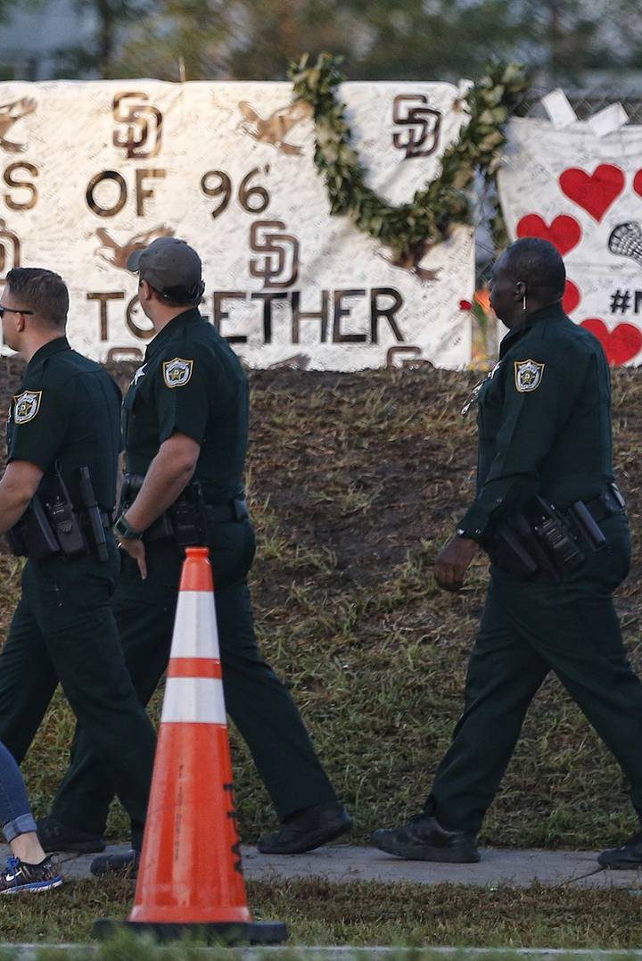 Marjory Stoneman Douglas High School staff, teachers and students return to school greeted by police and well wishers in Parkland, Florida on February 28, 2018. 
Students grieving for slain classmates prepared for an emotional return Wednesday to their Florida high school, where a mass shooting shocked the nation and led teen survivors to spur a growing movement to tighten America's gun laws. The community of Parkland, Florida, where residents were plunged into tragedy two weeks ago, steeled itself for the resumption of classes at Marjory Stoneman Douglas High School, where nearby flower-draped memorials and 17 white crosses pay tribute to the 14 students and three staff members who were murdered by a former student.
 / AFP PHOTO / RHONA WISE        (Photo credit should read RHONA WISE/AFP/Getty Images)