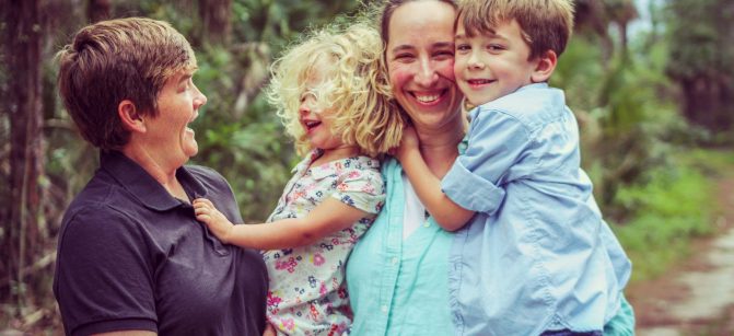 Adorable family, lesbian couple with two small children enjoy time together in the great outdoors