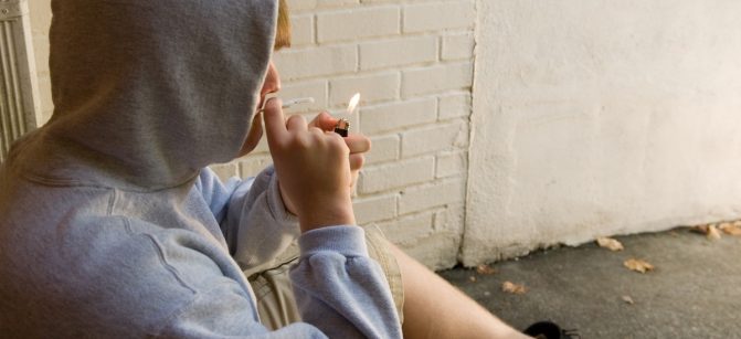 teen boy lighting a joint