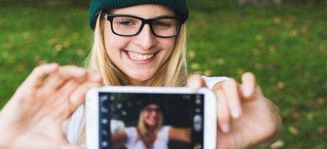 Blonde woman taking self portrait, selfie concept