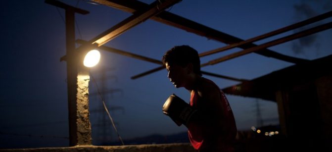 Javier Apolinar, 14, practises Olympics-style street boxing during a training session at a gym in the low-income neighborhood of La Vega in Caracas February 10, 2011. "Boxeo Olimpico de Calle" (Olympic Boxing Street) is an initiative of several institutions of the Venezuelan government, which aims to keep children off gangs and drugs in an attempt to combat high crime rates in the Caribbean nation. The program seeks to promote values such as discipline and respect and show that a better future is possible in a country that has nurtured several boxing champions. Picture taken February 10, 2011. REUTERS/Carlos Garcia Rawlins (VENEZUELA - Tags: SPORT BOXING SOCIETY) - GM1E7321SQB01