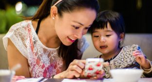 Young mom & toddler using smartphone cell parent  dinner