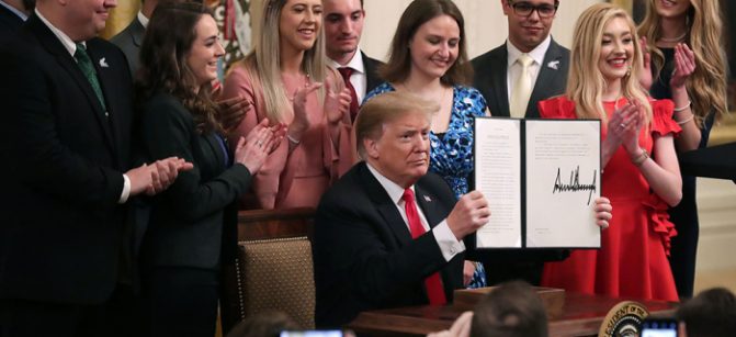 WASHINGTON, DC - MARCH 21: U.S. President Donald Trump holds up an executive order he signed protecting freedom of speech on college campuses during a ceremony in the East Room at the White House March 21, 2019 in Washington, DC. Surrounded by student who have said their conservative views are suppressed at universities across the country, Trump signed the order ‘improving free inquiry, transparency, and accountability on campus,’ according to the White House. (Photo by Chip Somodevilla/Getty Images)