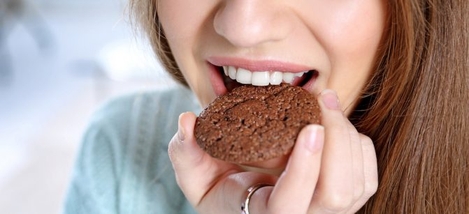 Young woman eating cookie, closeup