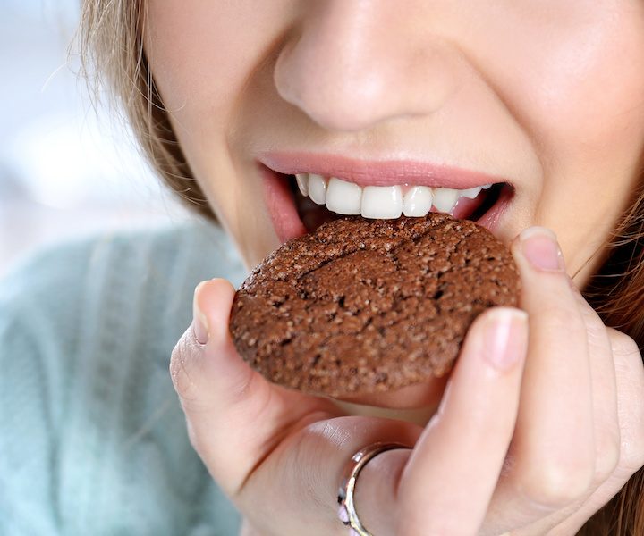 Young woman eating cookie, closeup