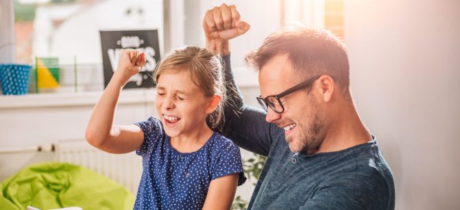 Father And Daughter Cheering during playing game on tablet