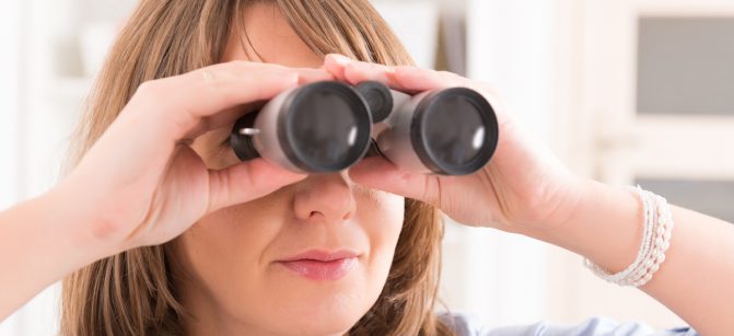 Beautiful woman Looking through binocular at home