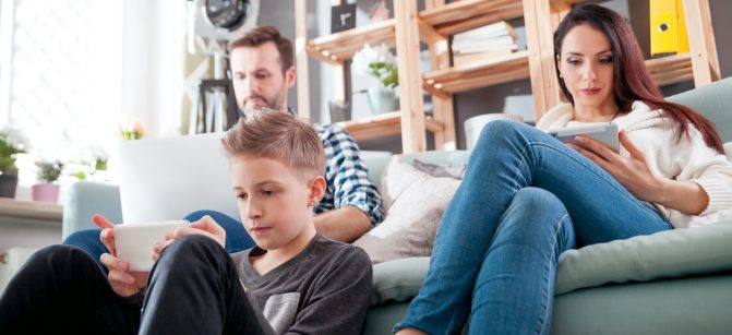 Family with laptop, tablet and smartphone at home, everyone using digital  cell devices