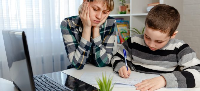 Mother working from home with child. Quarantine and closed school during coronavirus outbreak. Kid disturb woman at work. Homeschooling and freelance job