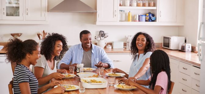 Family With Teenage Children Eating Meal In Kitchen